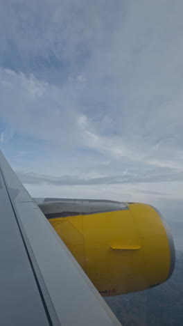 view from a plane window of the sky with the wing of the plane in shot in vertical