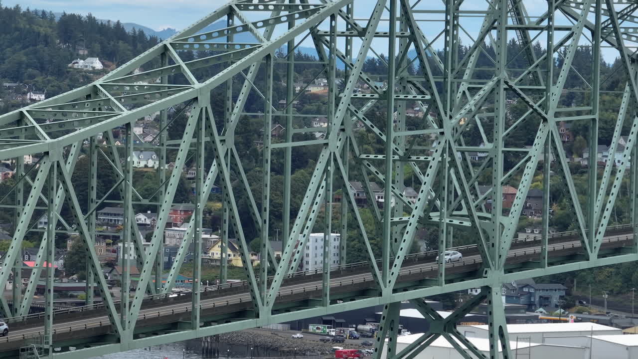 Telephoto drone shot around traffic on the Yaquina Bay Bridge, in cloudy Newport