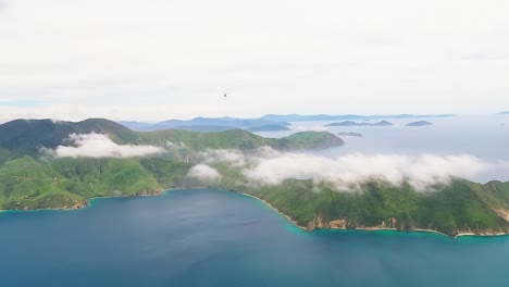 helicopter flying high over the white cloud covered, marlborough sounds towards the west, new zealand