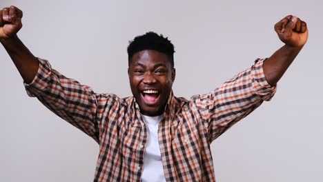 african american man celebrating victory by raising fist