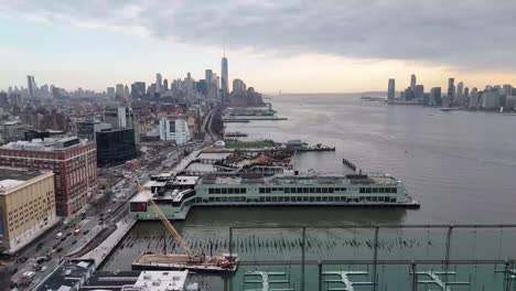 horizontal drone pull-away shot over 11th avenue in new york along the hudson river, revealing the city's waterfront, towering skyscrapers, and stunning manhattan skyline with smooth aerial motion.