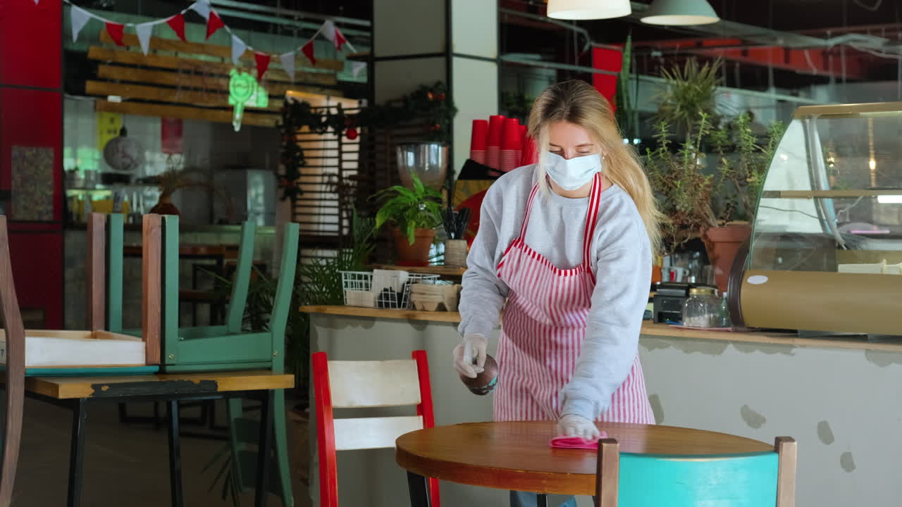 팬데 기간 동안 식당 직원이 테이블을 청소합니다.