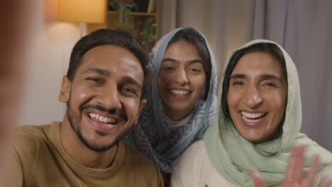 Toma-Pov-De-Una-Familia-Musulmana-Haciendo-Videollamadas-Sentados-Alrededor-De-La-Mesa-En-Casa