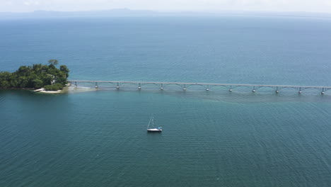 AERIAL---Long-bridge-between-islands-of-Samana,-Dominican-Republic,-wide-pan-right