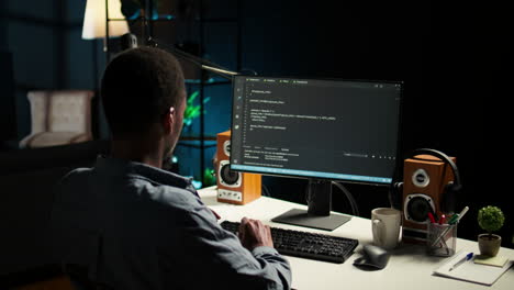 african american expert at desk using pc for programming and data analysis