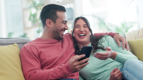 Couple,-laughing-and-talking-on-sofa-with-phone