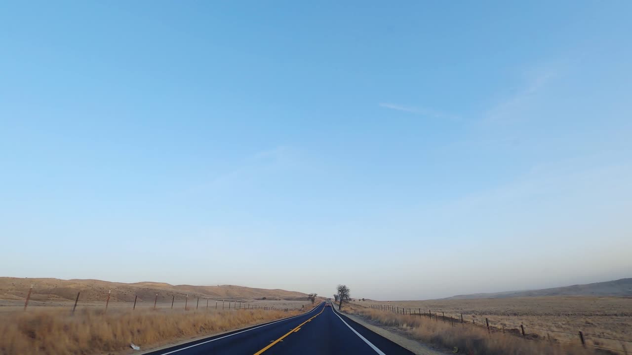 변화하는 계절에 드넓게 펼쳐진 노란 초원을 가로질러 도로를 달리다