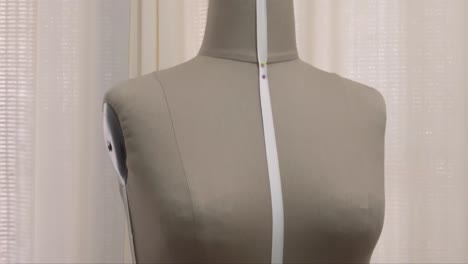 vertical panning shot of a seamstress mannequin at a fashion designer's studio