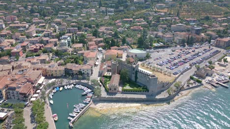 historic scaligero castle on lake garda coast, italy - aerial drone approach