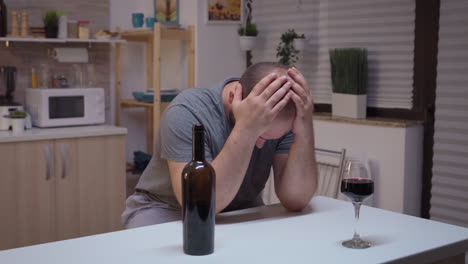 Sad-husband-drinking-in-the-kitchen