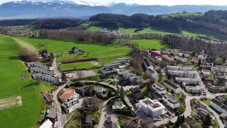 ciudad suiza con edificios y casas al lado del campo de hierba verde en la colina
