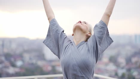 Retrato-De-Una-Mujer-Sonriente-Haciendo-Yoga-En-El-Sofá-Con-Bata-Hace-Un-Gesto-De-Namaste-Con-Las-Manos