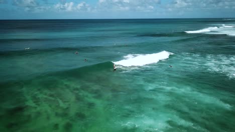 Aerial-shot-of-a-surfer-riding-a-large-wave-on-the-North-Shore-Coast-of-Oahu,-Hawaii