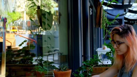 mujer joven usando teléfono móvil en un café al aire libre 4k