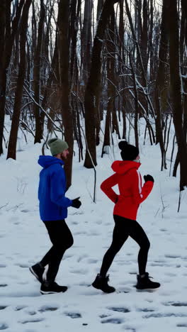 couple running in a snowy winter forest