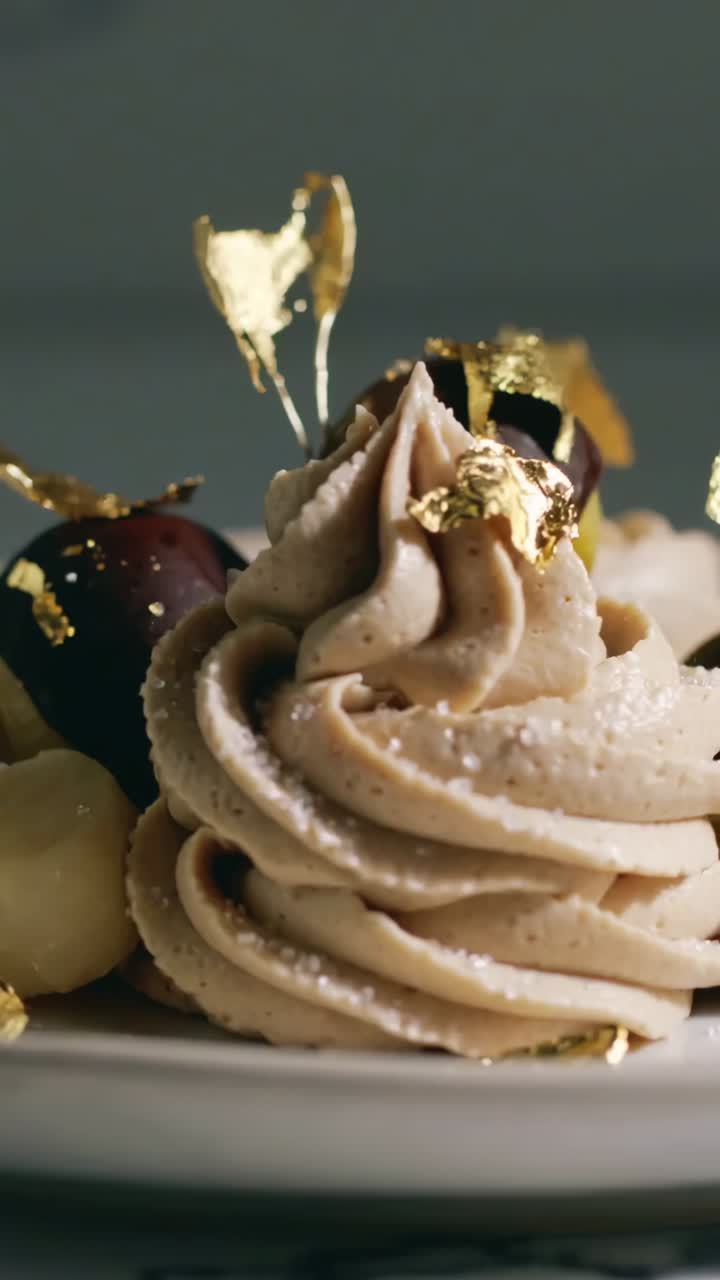 Video verticale: zoom indietro, la telecamera rivela il dessert sul tavolo, mostrando mousse, tartufo, foglia d'oro