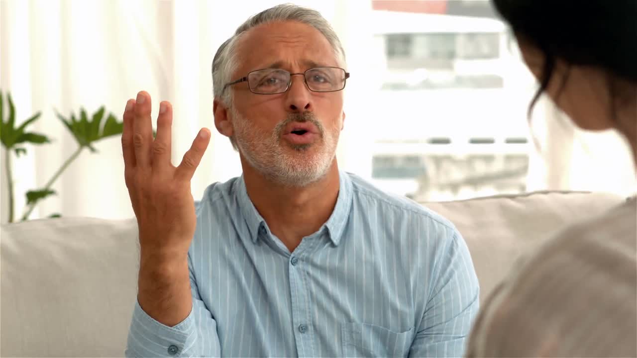 hombre ansioso hablando con un médico femenino en el sofá