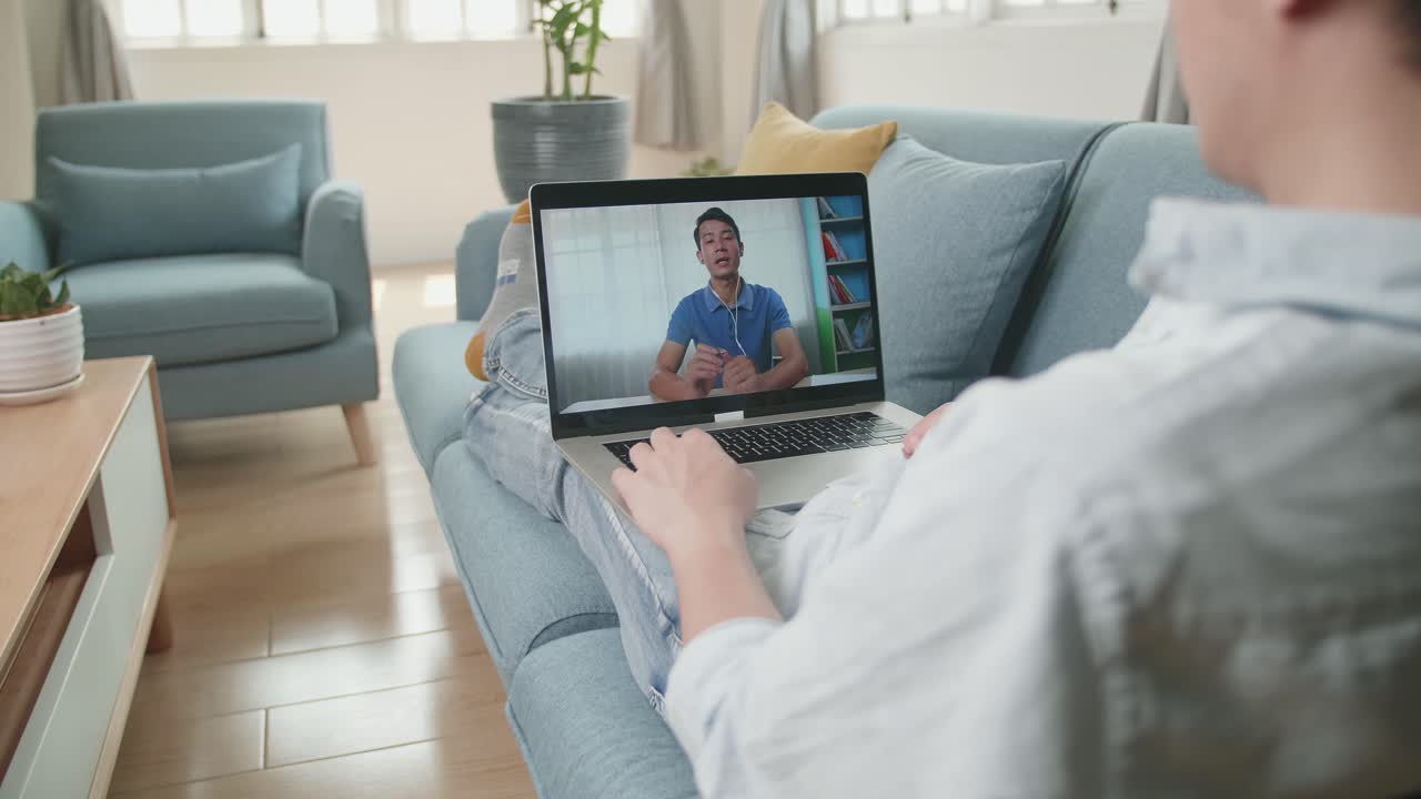 Man Greeting With Colleagues In Video Conference From Laptop At Living Room, Video In 4K