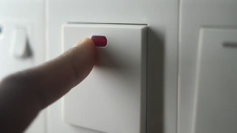 finger pressing wall light switch