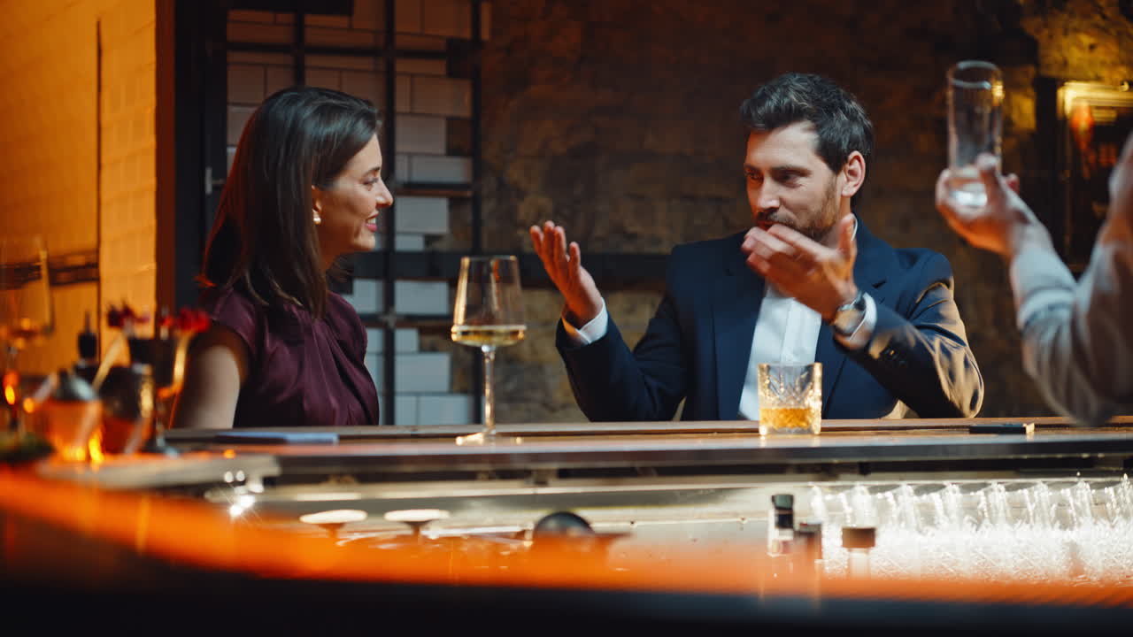 Coppia innamorata a un appuntamento che si diverte in un bar la sera, primo piano. Coppia che beve qualcosa