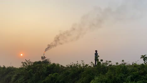 human and pollution concept, man exercising near industrial area, static, sunset