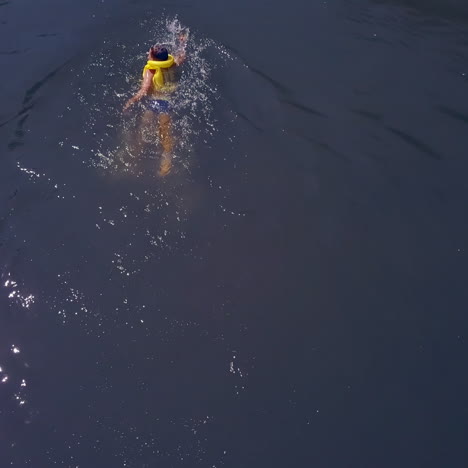 boy swims in the river in summer. happy children on summer vacation. aerial view.