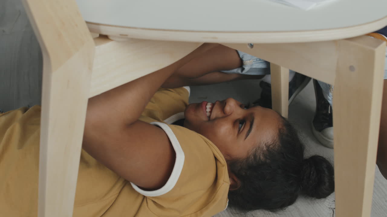 Una ragazza sotto un tavolo