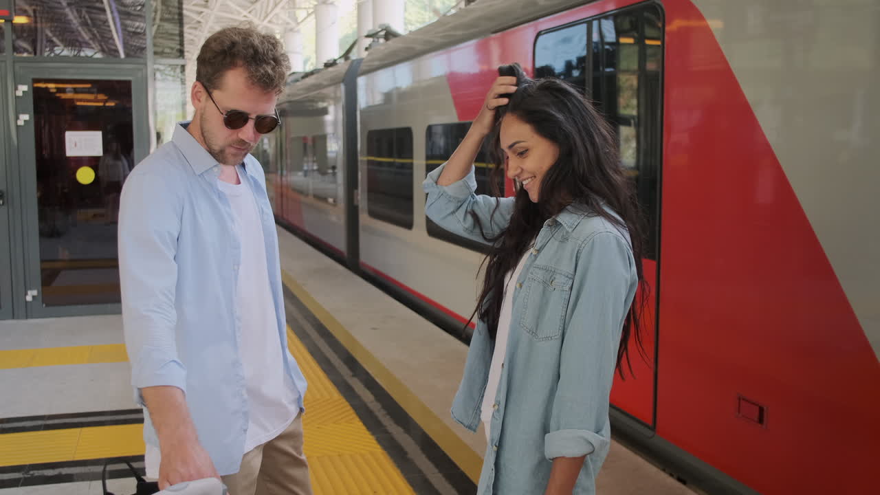 pareja esperando un tren en la estación