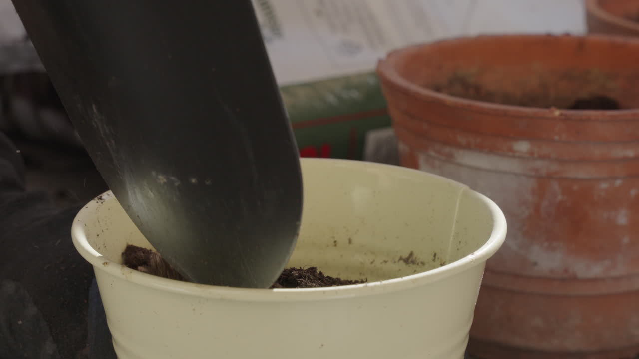 Filmato di una persona che mette terriccio in un piccolo vaso