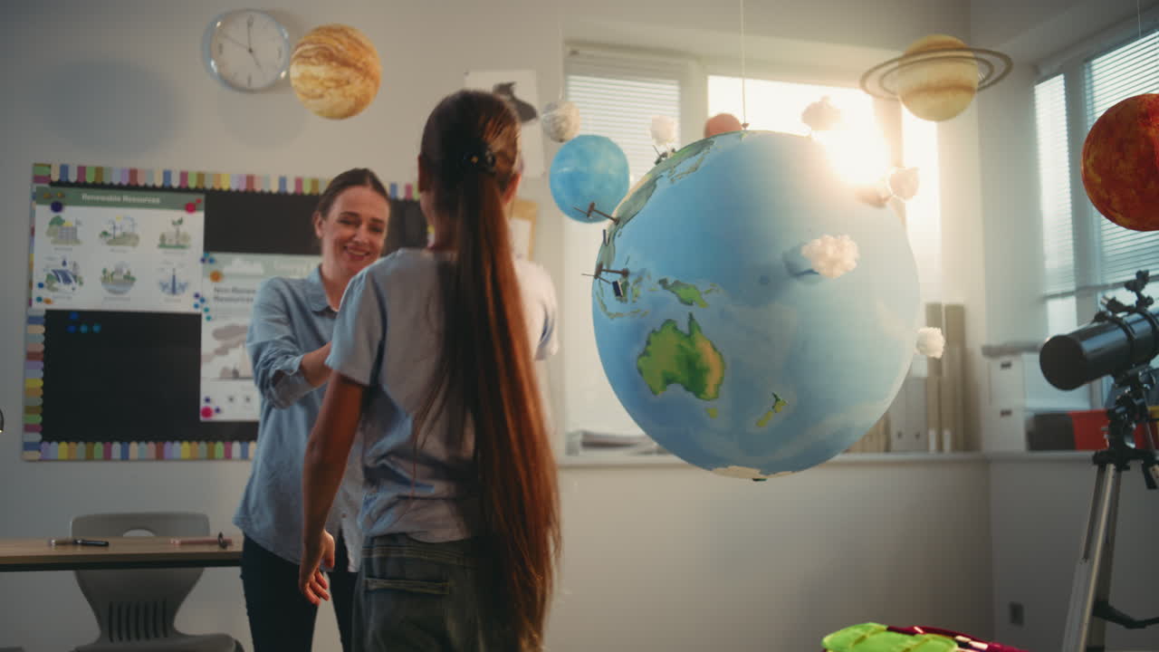 STEM Class School Girl Presenting Renewable Energy Sources Using Model of Earth