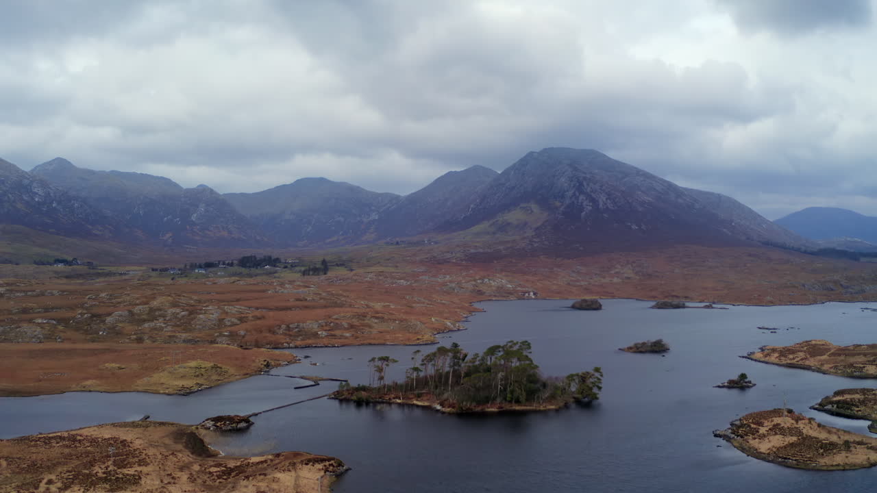 Establishing aerial shot of Connemara National Park featuring a beautiful lake and mountains.