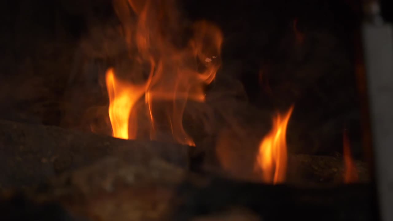 Slow Motion Orange Fire Flames Dance on Logs in Fireplace, Closeup