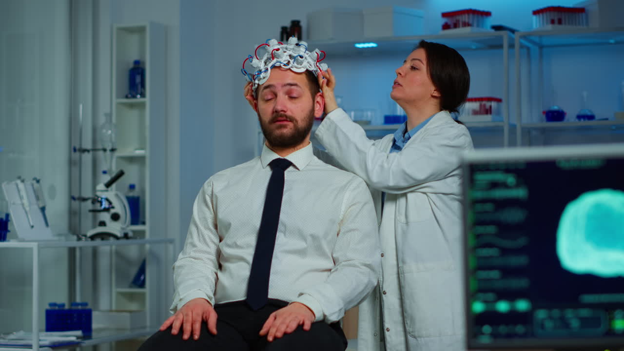 여성 연구원이 뇌파 스캔 헤드 ⁇ 을 착용하고 있습니다.