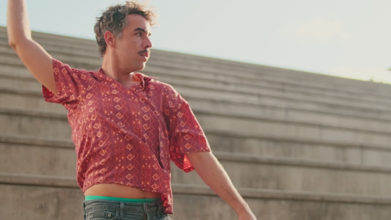 Hombre bailando danza contemporánea expresiva al aire libre en un día soleado
