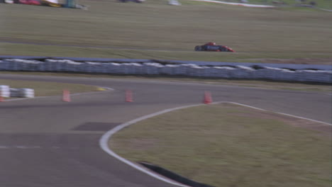 dos autos de carrera se dirigen hacia abajo en una pista