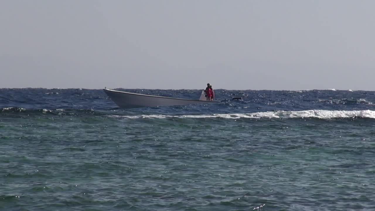 лодка в волнах сразу за рифом