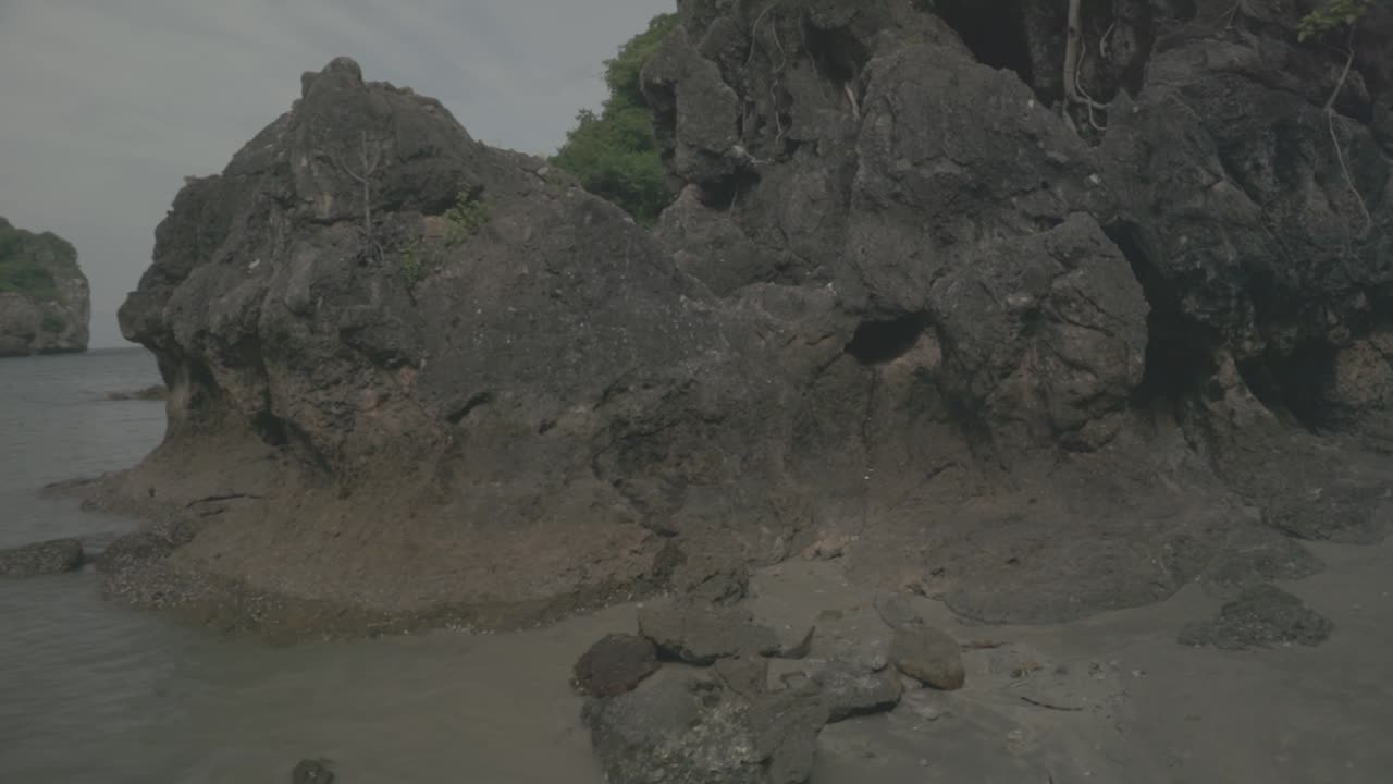 Walking towards the rock on the beach in thailand.