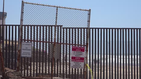 signs warn of a restricted area at the us mexico border fence in the pacific ocean between san diego and tijuana