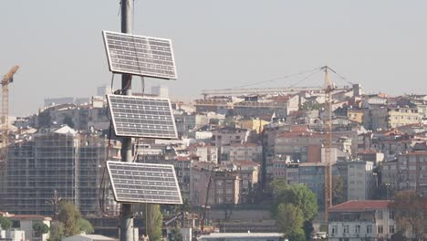 solar panels on a pole overlooking a dense urban cityscape with construction
