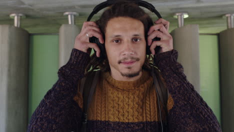retrato de un joven de raza mixta con rastas usando auriculares escuchando música
