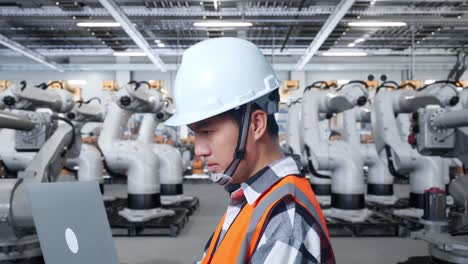 Engineer working with robots in a manufacturing facility