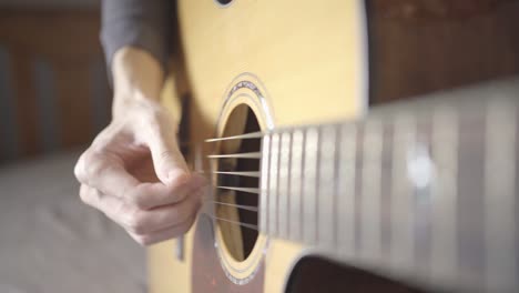 a man playing chords on acoustic guitar