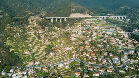 vista aérea de una ciudad montañosa con viñedos en terrazas y una carretera