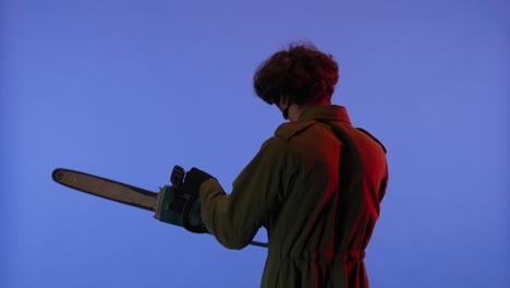 man in white mask with chainsaw in hands on blue background image of maniac jason voorhees from