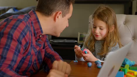 father and daughter playing with clay in living room 4k