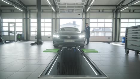 process of automatic suspension diagnostics in a modern auto service. professional equipment is used to inspect and analyze the condition of the vehicle's suspension and components