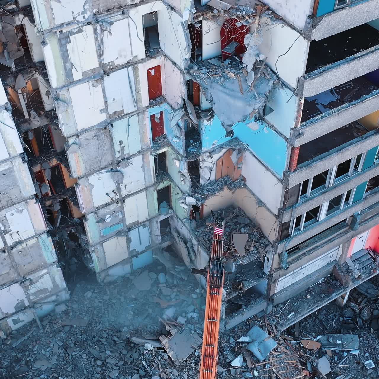 Deconstruction of old premises with the excavator claw. Heavy machinery demolishing debris and turning it into dust. View from above