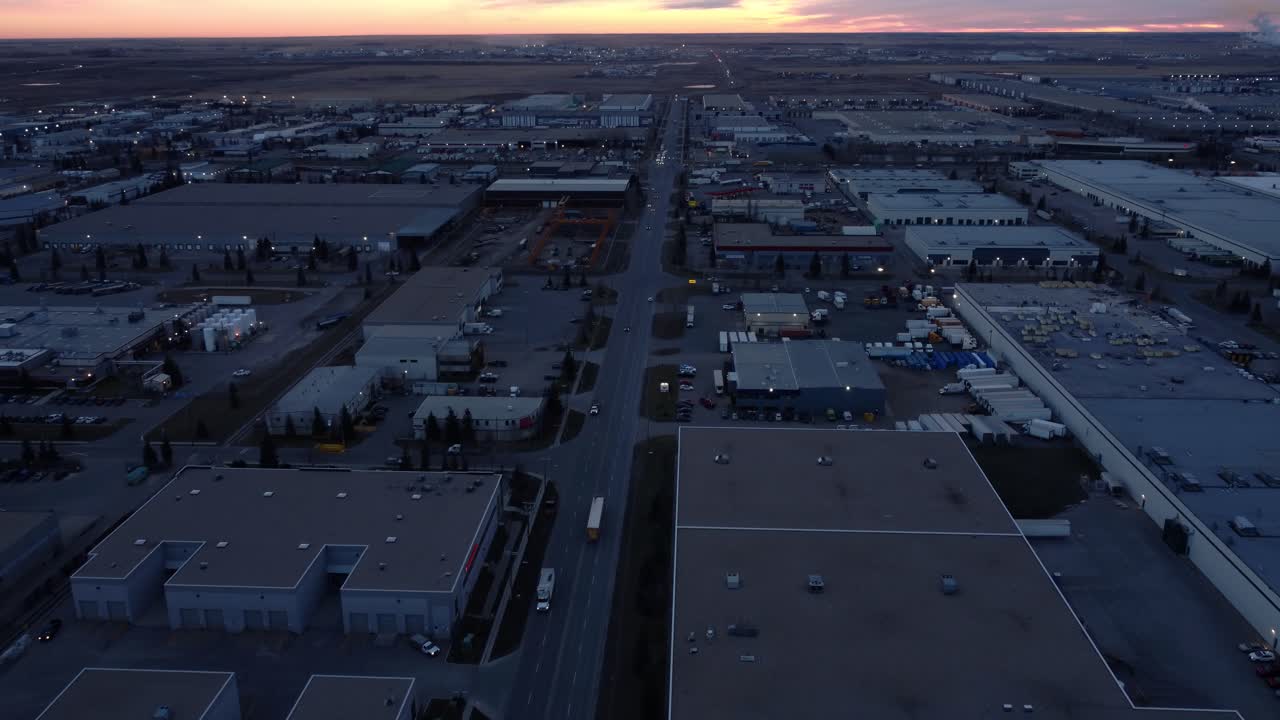 camión de larga distancia saliendo del área del almacén, dirigiéndose hacia el amanecer
