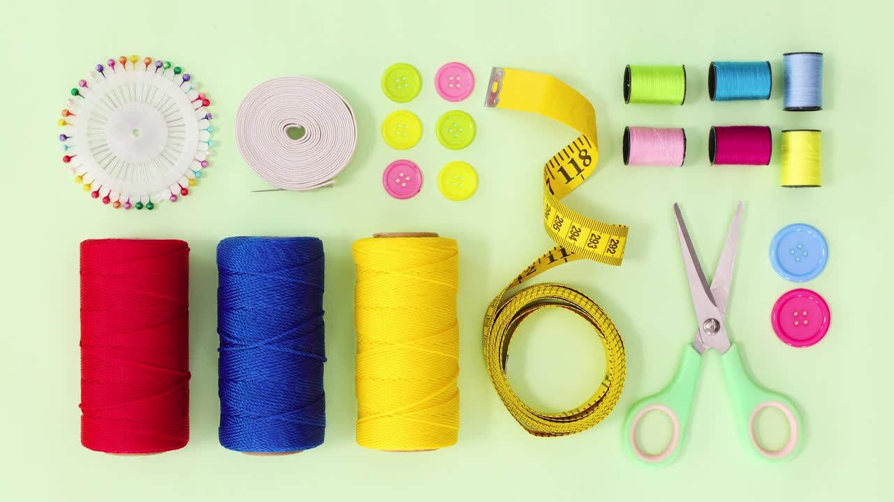 Sewing and knitting items make creative layout on green theme. Stop motion