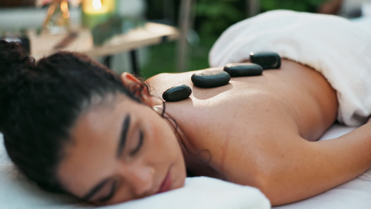 Woman receiving hot stone massage at spa